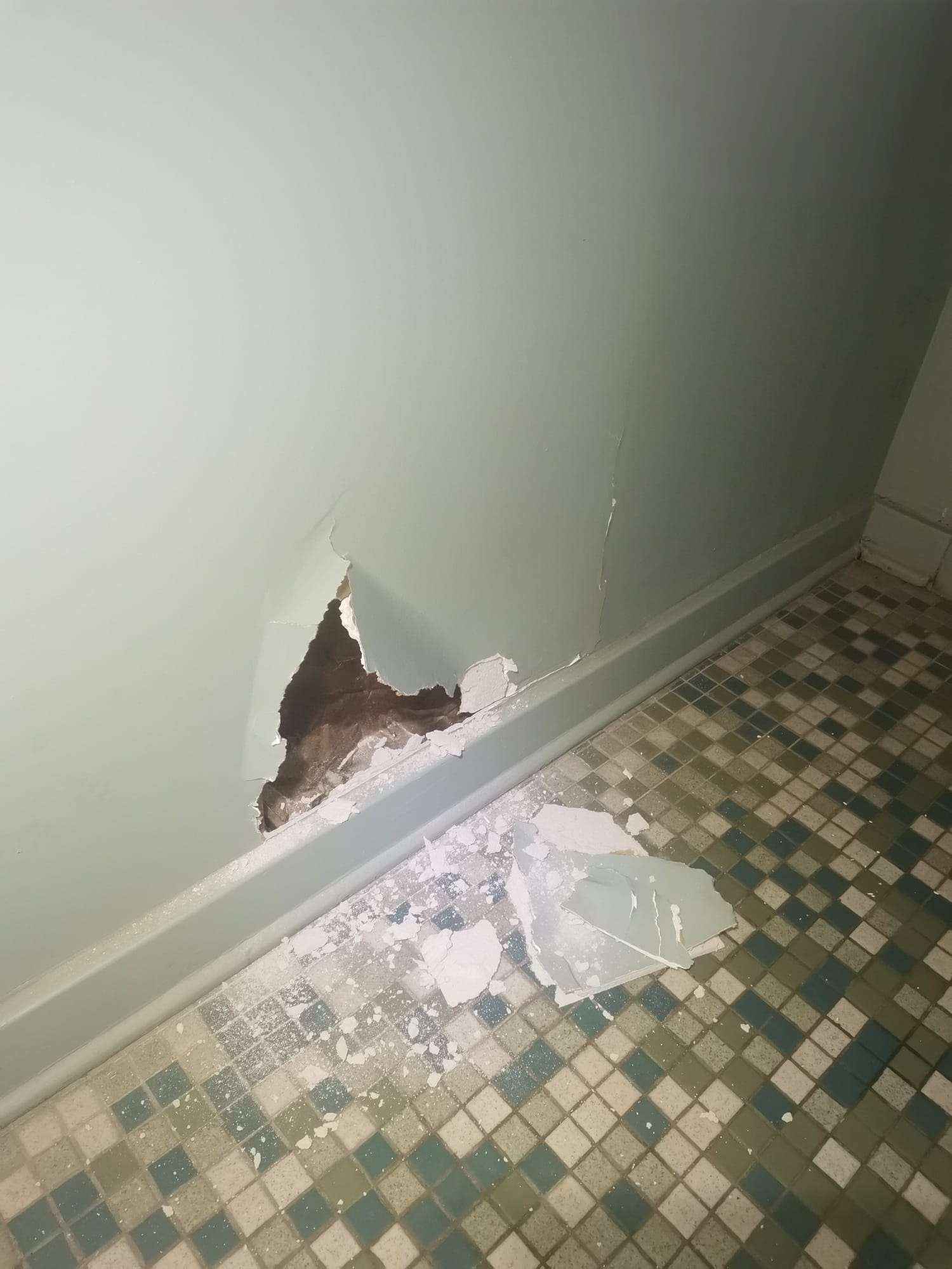 Large hole in drywall before repair