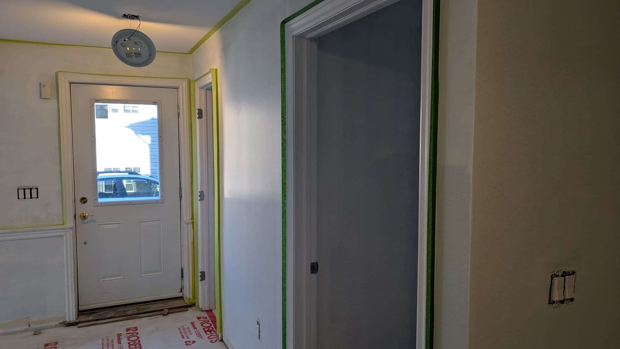Hallway and door trim carefully masked with green tape before painting